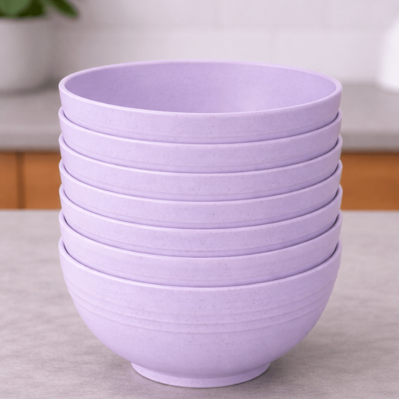 Stack of purple wheat straw bowls on a neutral background