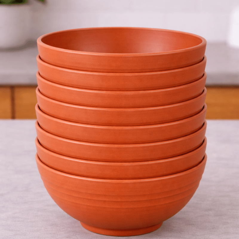 Stack of purple wheat straw bowls on a neutral background
